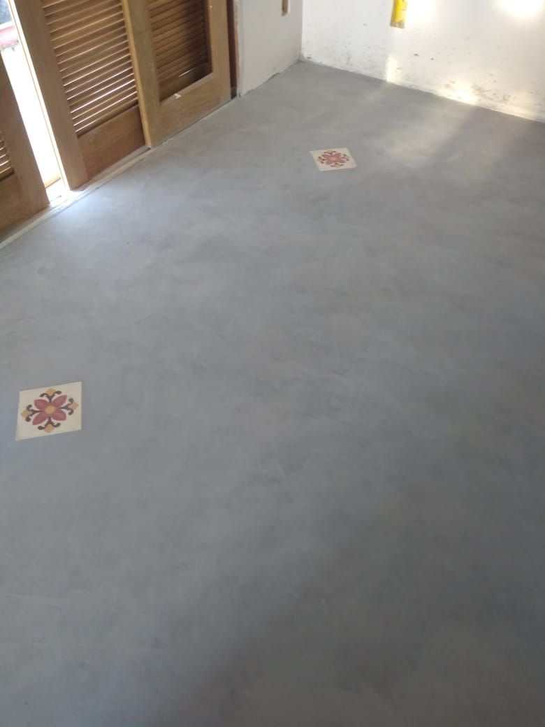 Piso em cimento queimado com ladrilhos hidráulicos decorativos embutidos e portas de madeira
