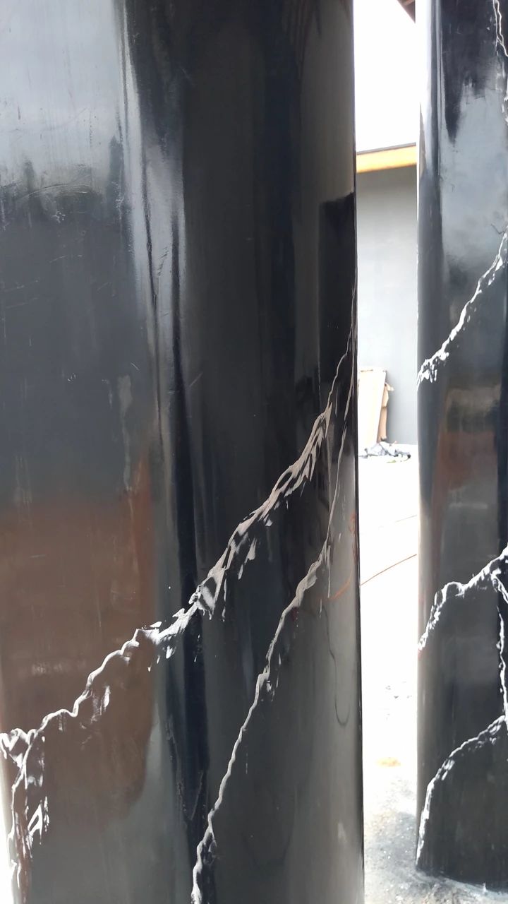 Colunas externas revestidas em marmorato preto brilhante com veios brancos